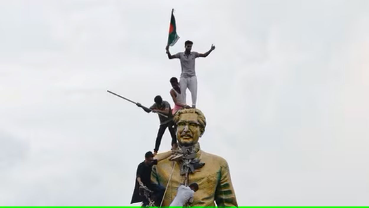 photo of protesters atop the statue of Sheikh Mujibur Rahman